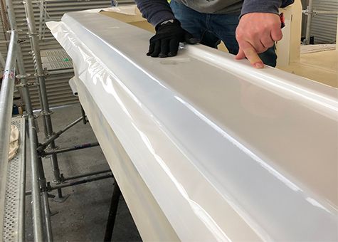 Vinyl being applied to boat gunwale
